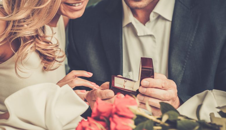 Man holding box with ring making propose to his girlfriend